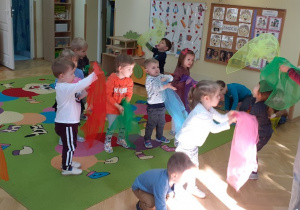 Dzieci tańczą z chustami na zajęciach rytmiki