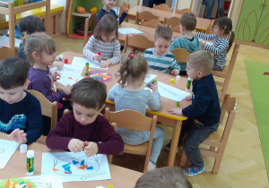 Dzieci oklejają instrumenty kolorowym papierem