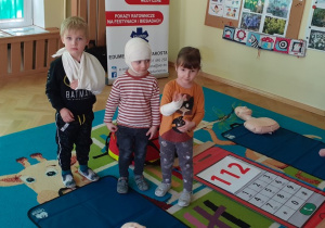 Dzieci prezentują opatrunki zrobione przez ratownika medycznego