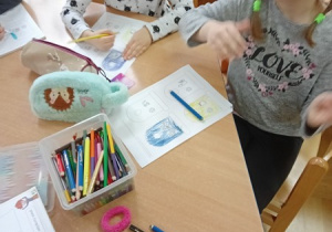 Dziewczynki kolorują pojemniki do segregacji na odpowiednie kolory