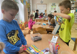 Dwóch chłopców wycina stojąc przy stoliku