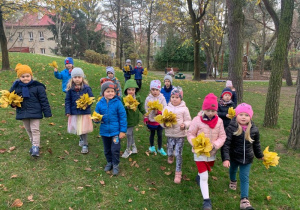 Grupowe zdjęcie dzieci z bukietami z liści