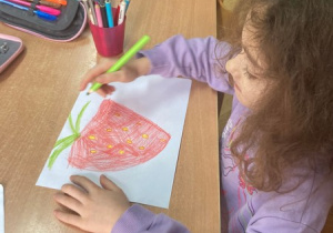 Dziewczynka rysuje truskawkę