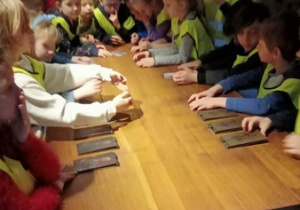 Dzieci uczestniczą w zajęciach w muzeum