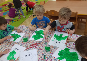 Dzieci malują sylwetki żaby - praca plastyczna