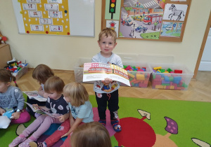 Chłopiec prezentuje obrazki z książki