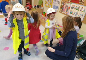 Dzieci prezentują strój ochronny budowniczego