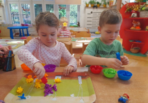 Kolejne nowości w Kąciku Sprytnej Rączki - segregowanie dinozaurów przy pomocy szczypiec