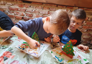 Chłopcy ozdabiają choinki