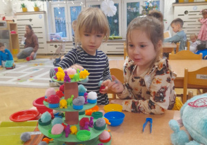 W naszym Kąciku Sprytnej Rączki pojawiła się nowa, ciekawa pomoc - choinka, zbudowana z tekturowych kół, rolki po ręczniku papierowym i korków