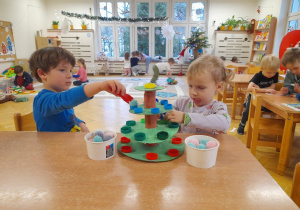 Z pozoru proste układanie pomponików szczypcami - w tak naprawdę ćwiczenie ręki, koncentracji, skupienia uwagi, koordynacjo oko - ręka, utrwalanie kolorów, przeliczanie, współdziałanie z inną osobą...