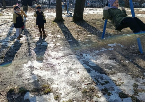 Zabawy na huśtawkach na pobliskim placu zabaw