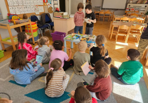 Chłopcy czytają samodzielnie napisaną książeczkę